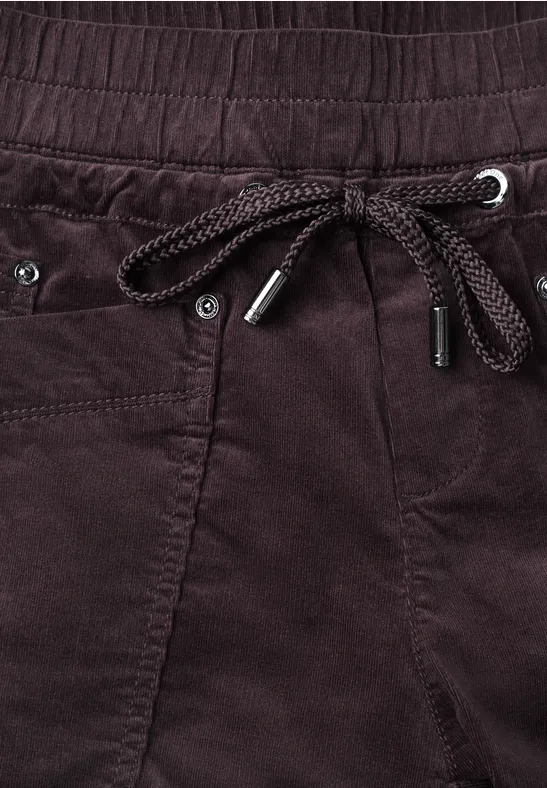 Dunkelrote Cordhose mit elastischem Bund und geflochtenem Kordelzug, Metallösen und Metallenden.