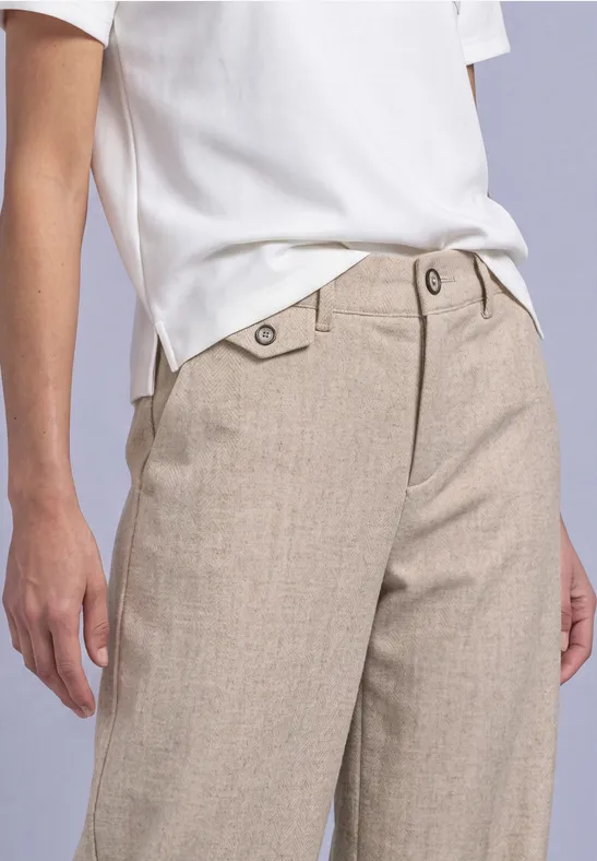 Beige, wijde linnen broek met knoopdetail en wit T-shirt.