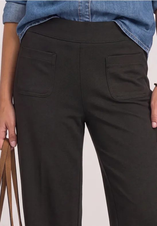 Bild zeigt dunkelgrüne Damenhose mit aufgesetzten Taschen, dazu Jeanshemd und Henkel einer braunen Tasche