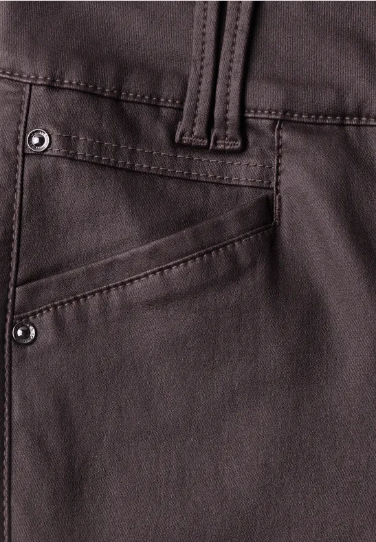 Nahaufnahme einer dunkelbraunen Lederhose mit Tasche und Nieten.
