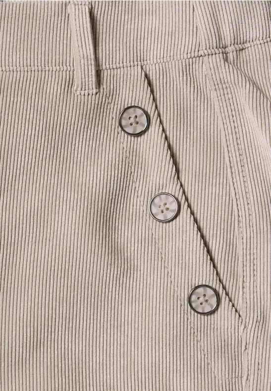 Beige gestreiftes Kleidungsstück aus Stoff mit drei Zierknöpfen an einer diagonalen Seitennaht.