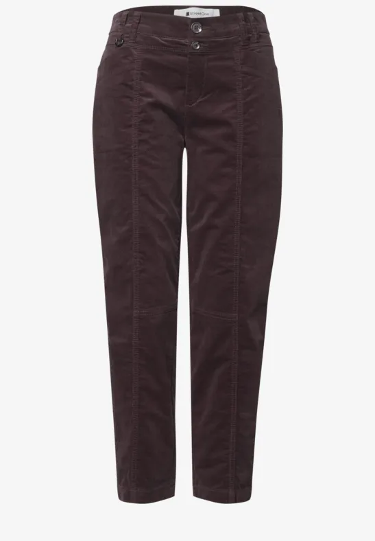 Weinrote Cordhose mit hoher Taille, sichtbaren Nähten und schmalem, leicht verkürztem Bein.