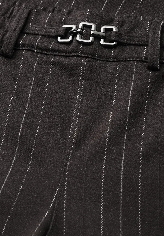 Detailaufnahme eines schwarzen Nadelstreifen-Stoffes mit verstellbarem Metallverschluss an der Taille.