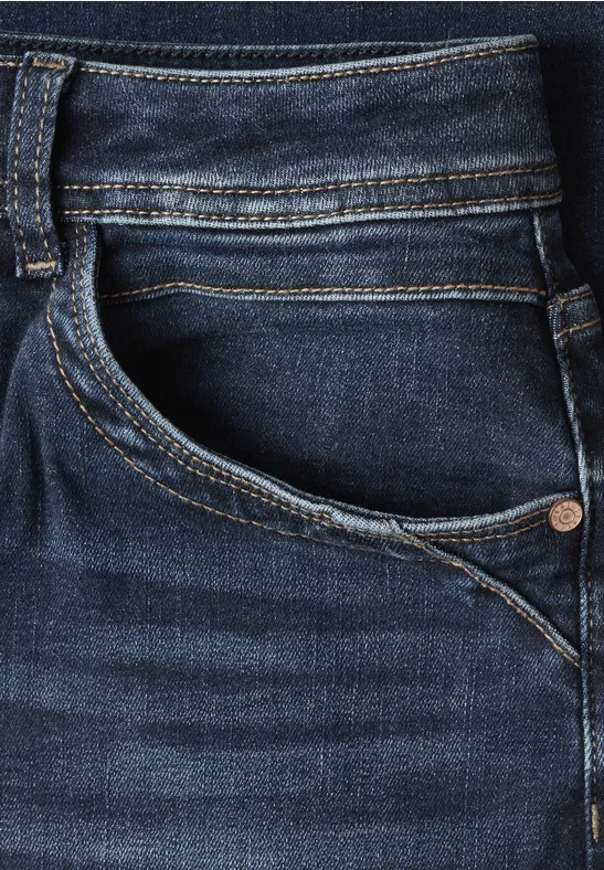 Nahaufnahme einer dunkelblauen Jeans mit sichtbarer Tasche und Naht.