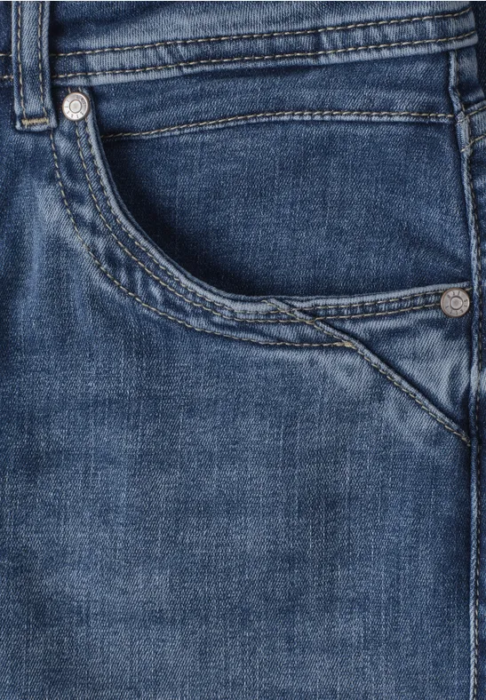 Nahaufnahme einer blauen Jeansvorderseite mit Tasche und sichtbarer Naht.