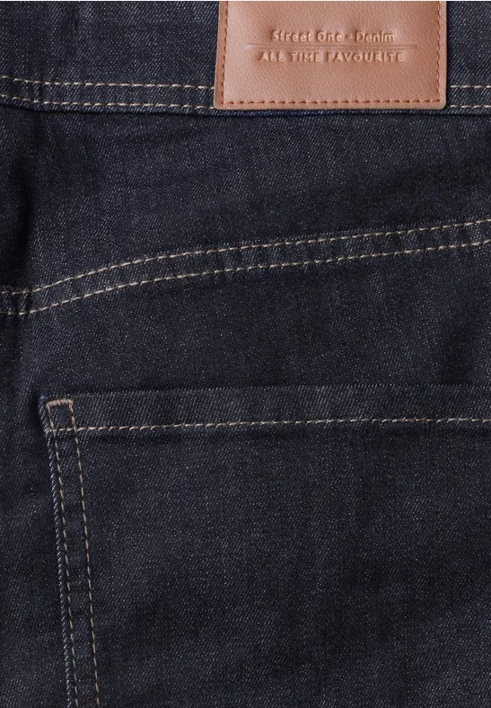 Nahaufnahme einer dunkelblauen Jeans mit braunem Lederpatch und gelben Nähten an der Gesäßtasche.