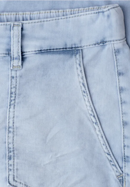 Nahaufnahme hellblauer Denim-Jeans mit Seitentasche und Gürtelschlaufen.