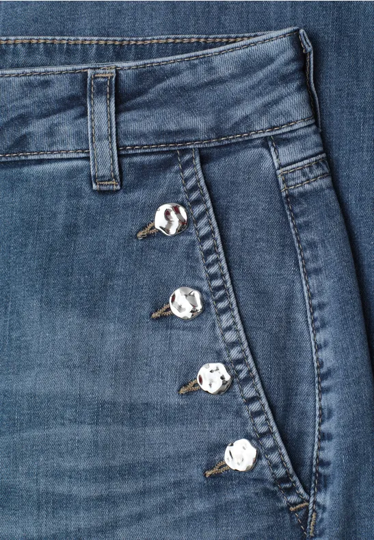 Jean bleu avec poche latérale et quatre boutons argentés le long de la couture.