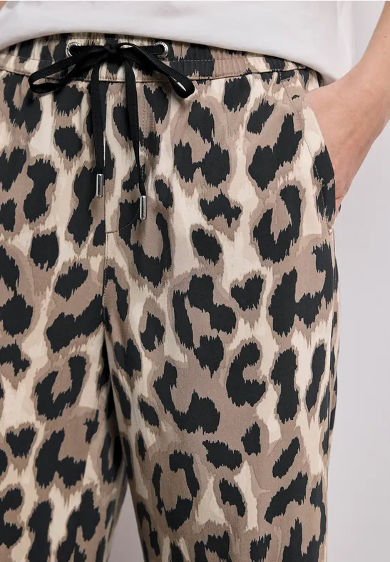 Beige Hose mit schwarzem Leopardenmuster und Bindeband am Bund.