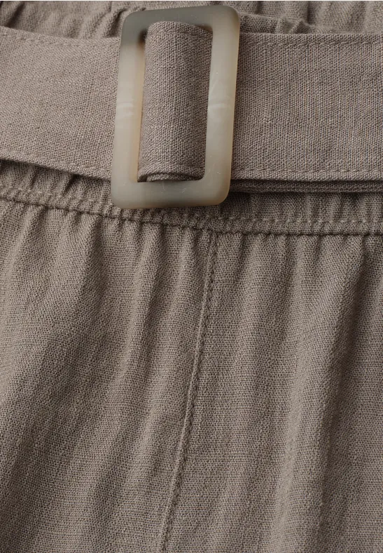 Detail eines beigen Leinenbunds mit eingenähtem Gürtel und passender rechteckiger Schnalle