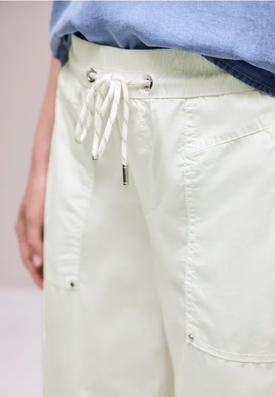 Lichte, losse broek met trekkoord en opgestikte zakken, gecombineerd met een blauw T-shirt.