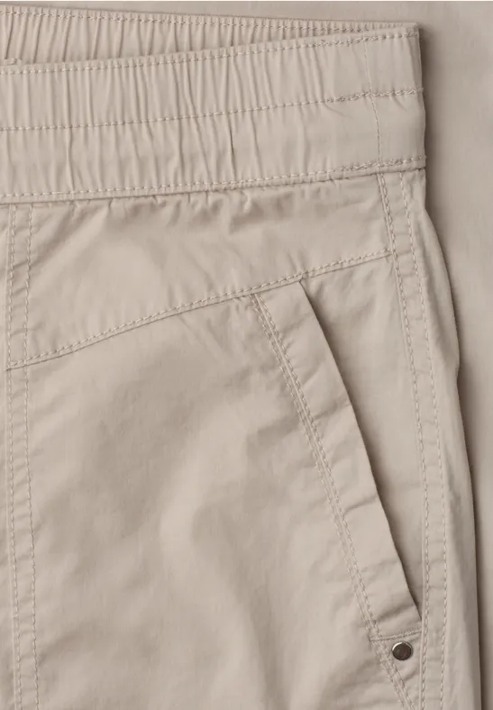 Beige broek met een elastische taille en een schuine zijzak.