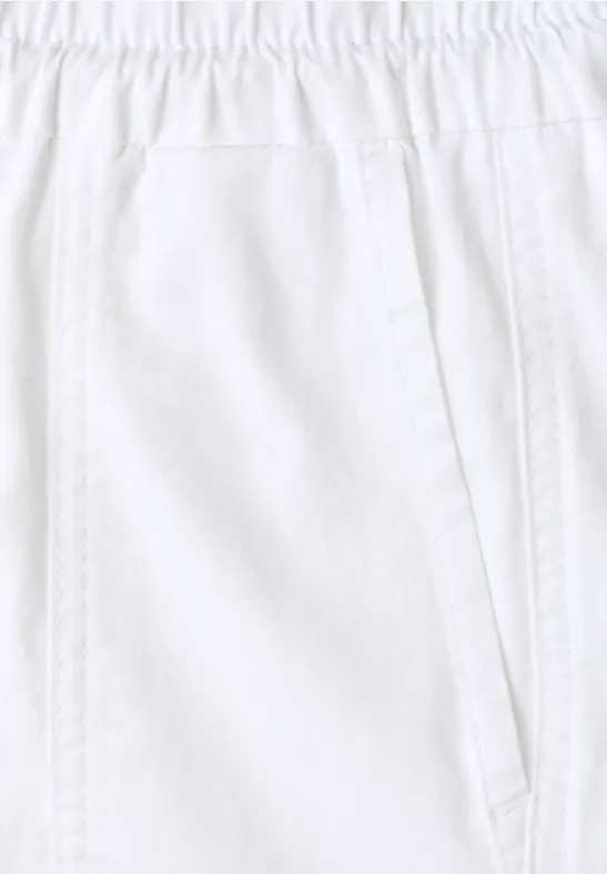 Close-up van een witte broek met elastische tailleband en zijzak.