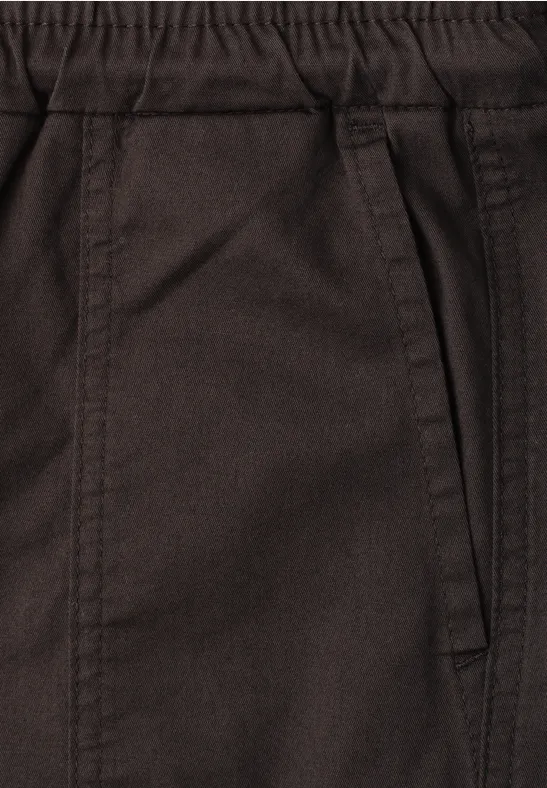 Nahaufnahme einer braunen Hose mit elastischem Bund und seitlicher Tasche.