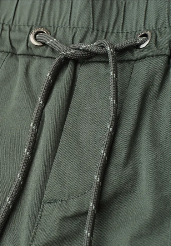 Nahaufnahme einer dunkelgrünen Hose mit elastischem Bund und grauem Kordelzug.