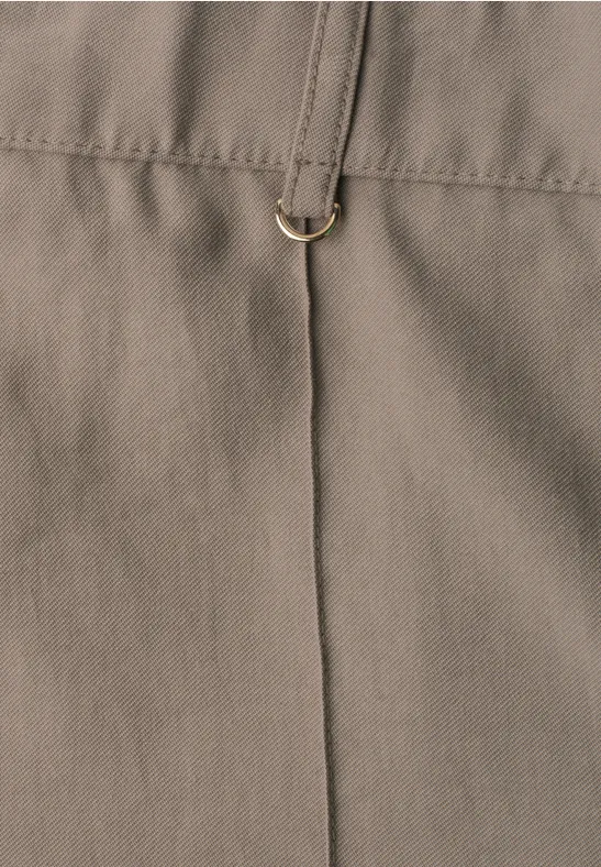 Close-up van kaki gekleurde stof met verticale naad en gouden D-ring.