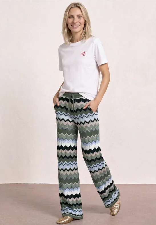 Vrouw met wit T-shirt en wijde broek met golvend patroon