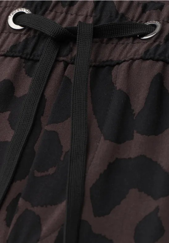 Close-up van camouflagestof met trekkkoord en metalen ringen in de tailleband.