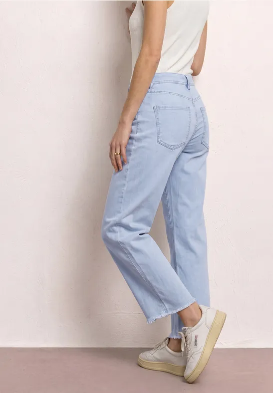 Zijaanzicht van een vrouw in lichtblauwe, rechte jeans met hoge taille.