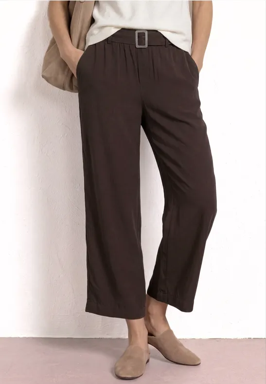 Pantalon marron large, longueur chevilles, taille élastique avec ceinture, porté avec des mocassins beiges.