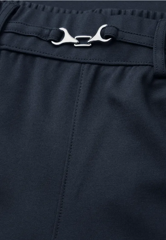 Dunkelblaue Hose mit verstellbarem, schraubenschlüsselähnlichem Metallverschluss am Bund