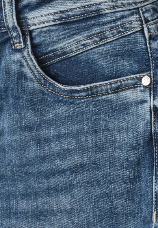 Nahaufnahme von blauen Jeans, die vordere Tasche und Nahtdetails zeigen.