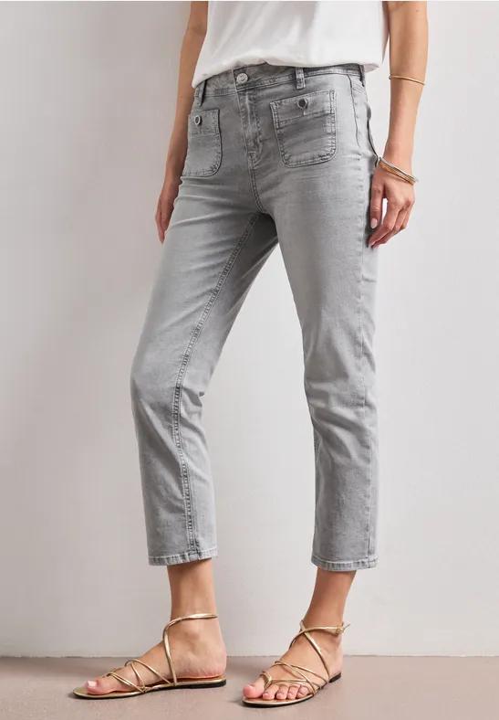 Hellgraue, verkürzte Damen-Jeans kombiniert mit filigranen Riemchensandalen.