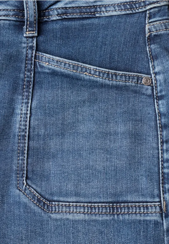 Detailaufnahme einer blauen Jeanshose mit Vordertasche und Gürtelschlaufe