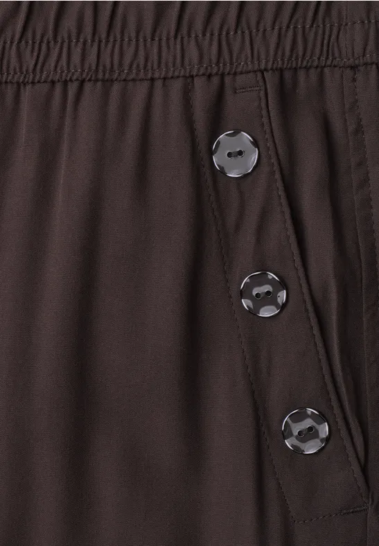 Dunkelbraune Hose mit elastischem Bund und drei Druckknöpfen an der Seite.