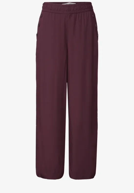 Weit geschnittene, bordeauxrote Hose mit elastischem Bund und geraden Beinen.