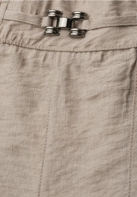 Helles Leinengewebe mit verstellbaren Metall-Schnallen, Detailaufnahme.