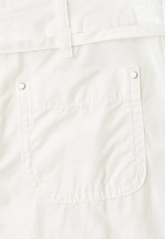 Nahaufnahme einer aufgesetzten Tasche an einer weißen Hose mit Gürtelschlaufen.