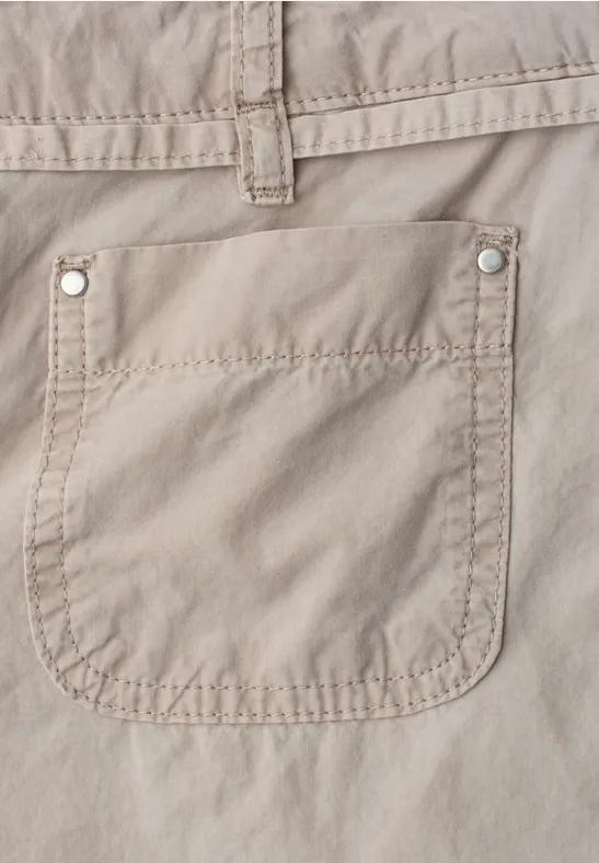 Nahe Nahaufnahme einer beigen Stoffhose mit aufgesetzter Tasche.