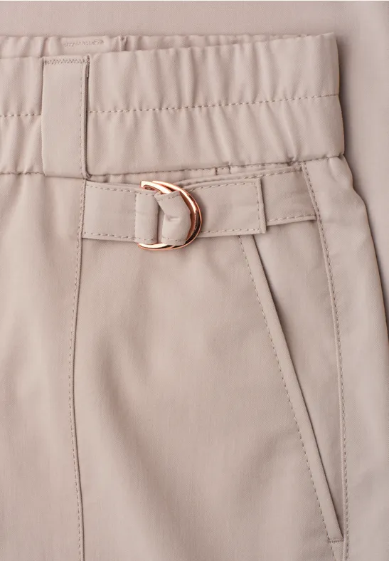 Beige broek met elastische taille, smalle ceintuur met gouden metalen gesp en schuine zak.