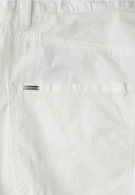 Nahaufnahme einer weißen Hosentasche mit Metall-Label