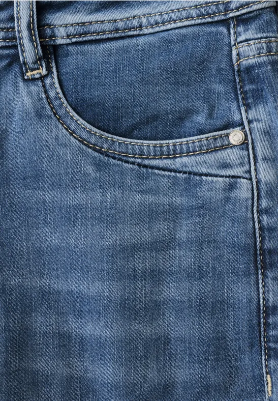 Gros plan sur un jean bleu avec poche avant et passants de ceinture.