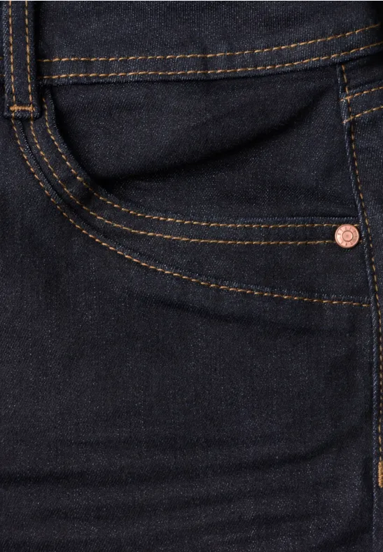 Dunkle Jeans mit sichtbarer Gesäßtasche, Doppelnähten und Kupfernieten.