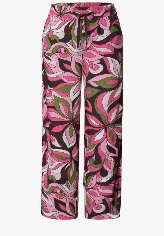 Wijde palazzo-broek in roze, groen en zwart met abstract bloemmotief.