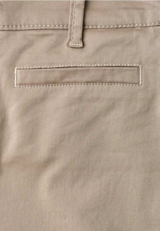 Close-up van een lichtbeige broek met een ingewerkt achterzakje en een riemlus.