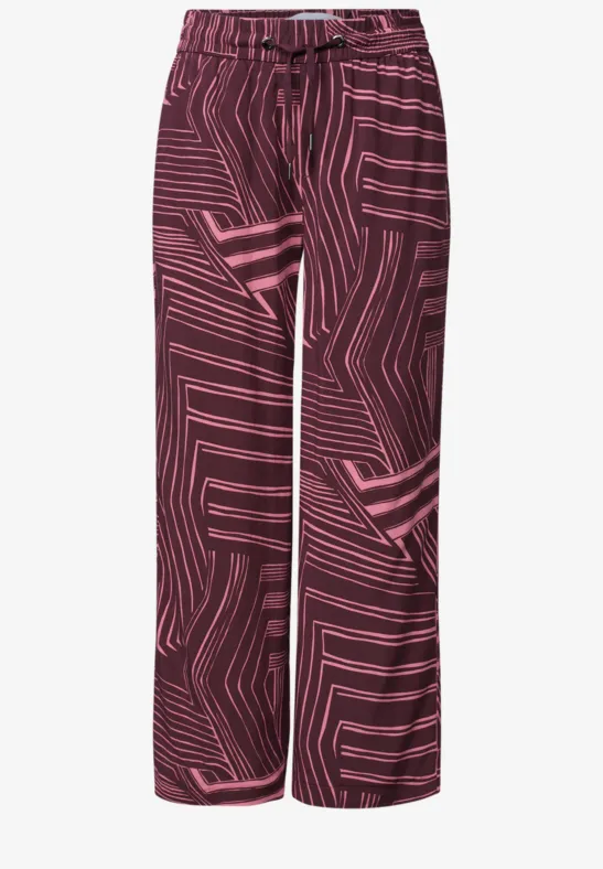 Pantalon ample bordeaux à motif géométrique rose.