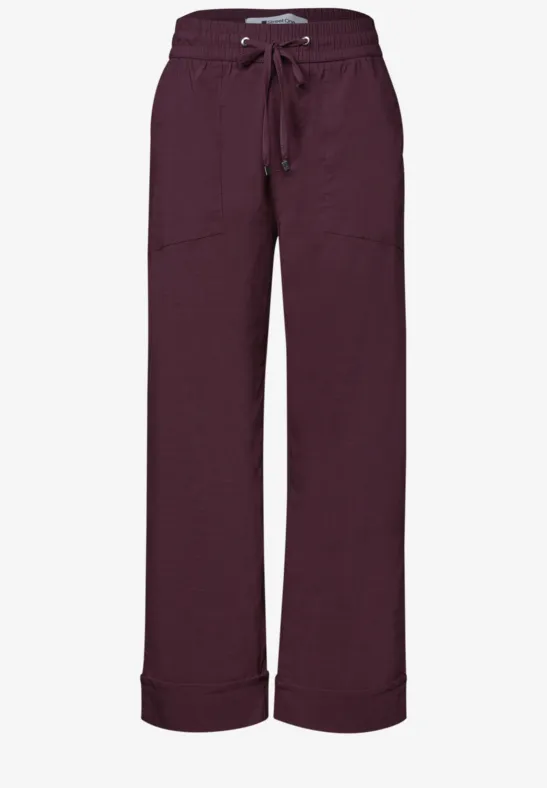 Dunkelviolette, lockere Hose mit Kordelzug, seitlichen Taschen und weitem Bein.