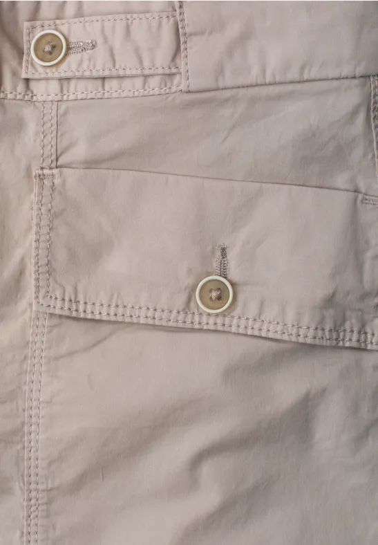 Nahaufnahme einer hellbeigen Stofftasche mit Knopfverschluss und sichtbaren Nähten.