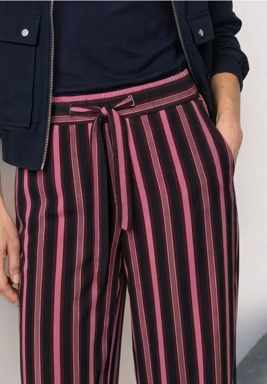Gestreifte Hose mit schwarzen und pinken Längsstreifen und Stoffgürtel.