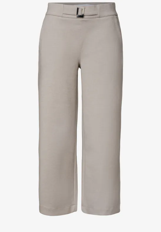 Lichtbeige wijde enkellange broek met hoge taille, plooien vooraan en bijpassende riem.