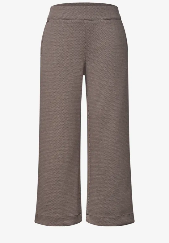 Braune, weite, hochgeschnittene Damenhose aus weichem Stoff.
