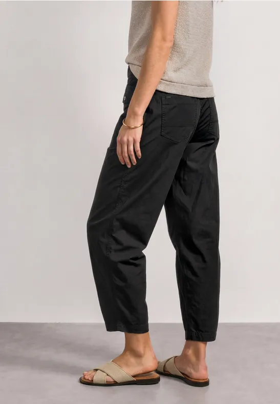 Schlichte schwarze Hose und helle Sandalen, lässig geschnitten