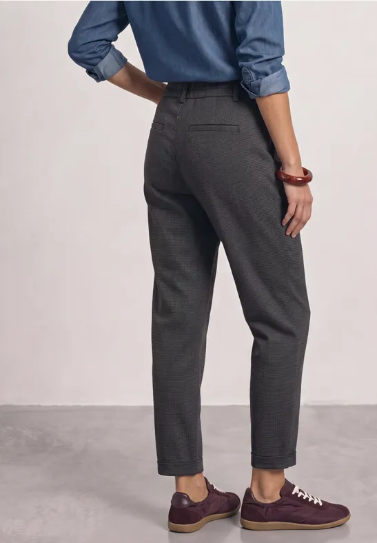 Vue arrière d'une personne portant un pantalon gris, une chemise bleue et des baskets bordeaux