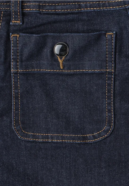 Nahaufnahme einer dunkelblauen Jeans mit orangefarbener Naht und Knopf an einer aufgesetzten Tasche.