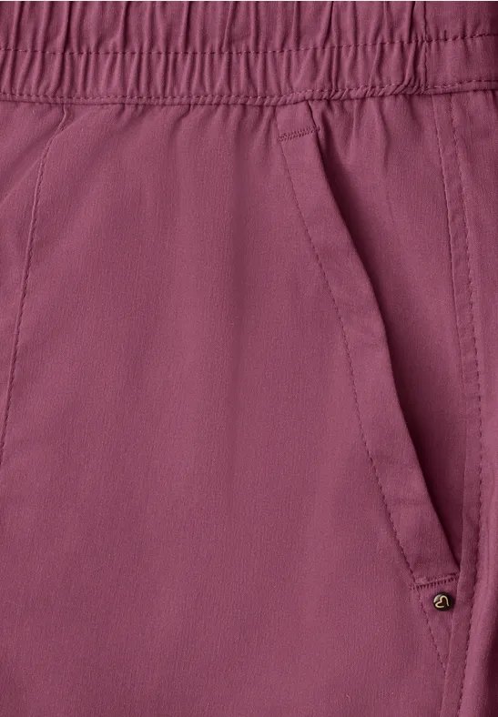 Nahaufnahme einer himbeerfarbenen Hose mit elastischem Bund und schräger Seitentasche.