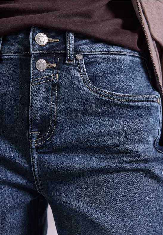 Nahaufnahme dunkler Jeans mit sichtbaren Taschen und doppeltem Knopfverschluss.